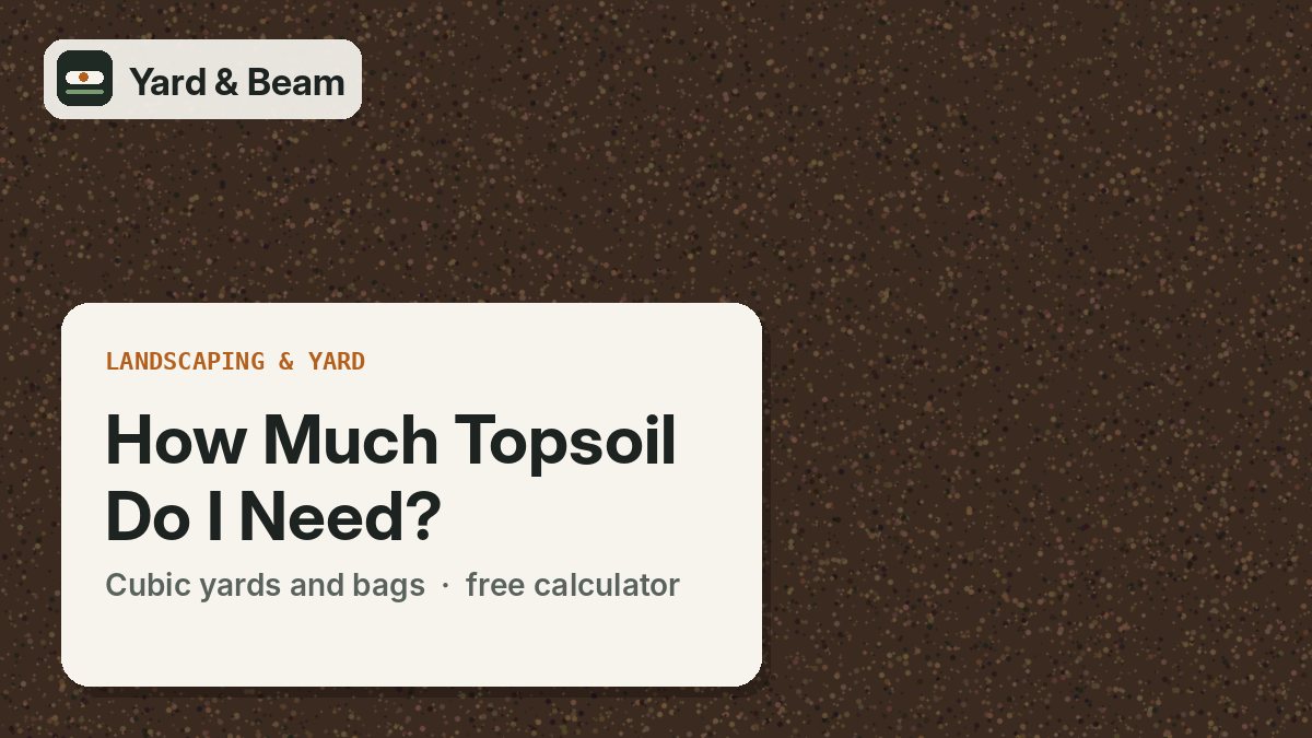 Pile of dark topsoil on a bare yard with a rake and a wheelbarrow